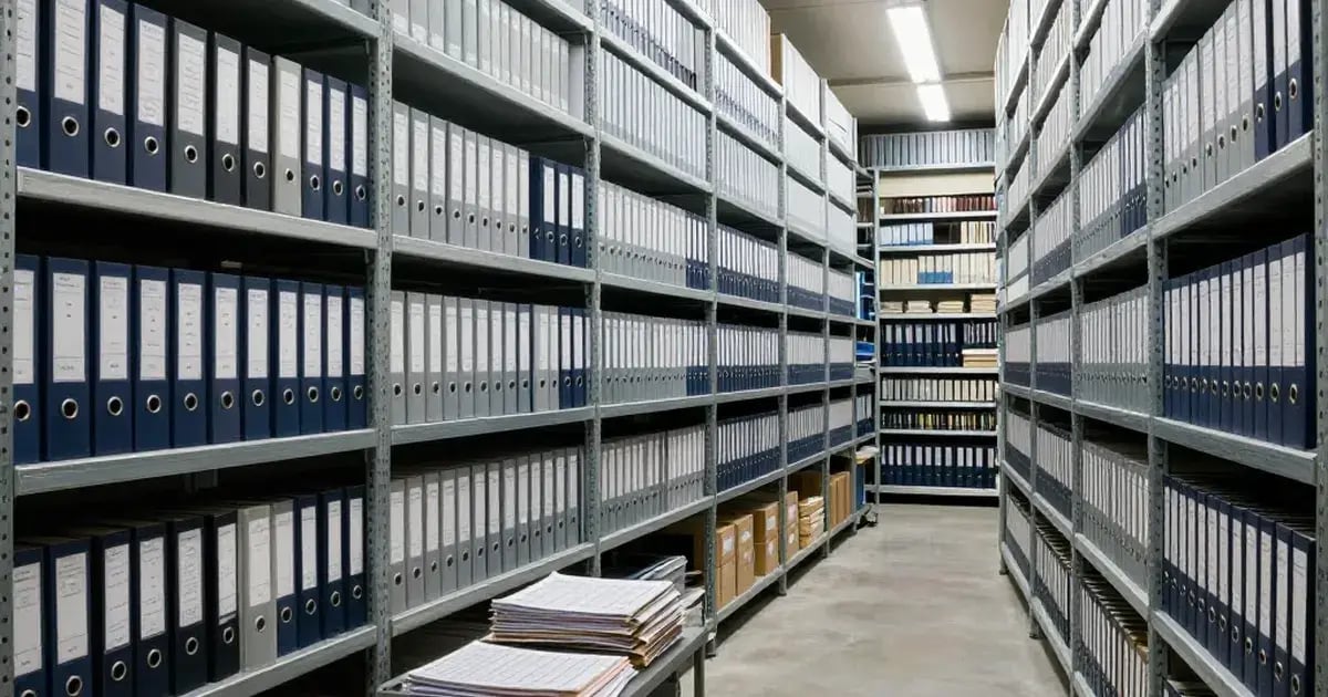 Climate-controlled records room with floor-to-ceiling shelves of blue binders and archival boxes