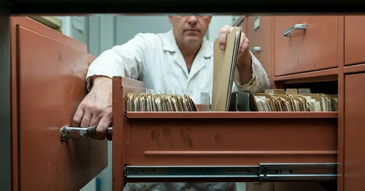 Quality manager retrieves one kraft folder from a supported lateral file drawer.