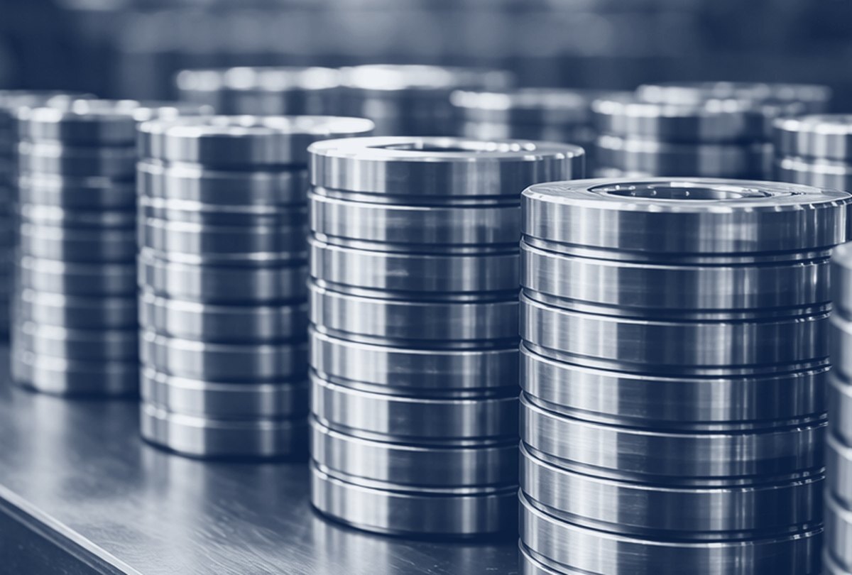 Stacks of machined steel bearing rings, in navy tones.